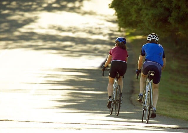 Couple cycling on side of road