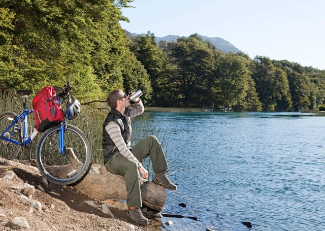 Mountain biker drinking by lake