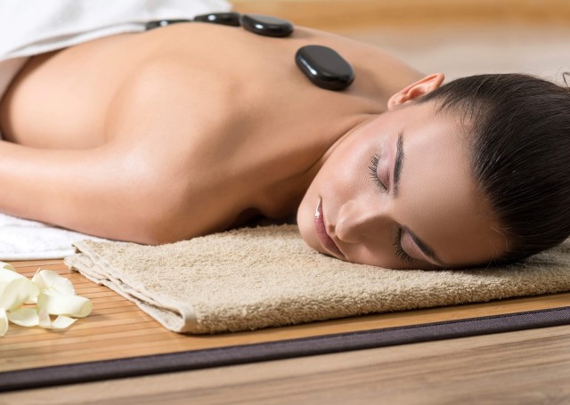 A woman receiving a hot stone massage