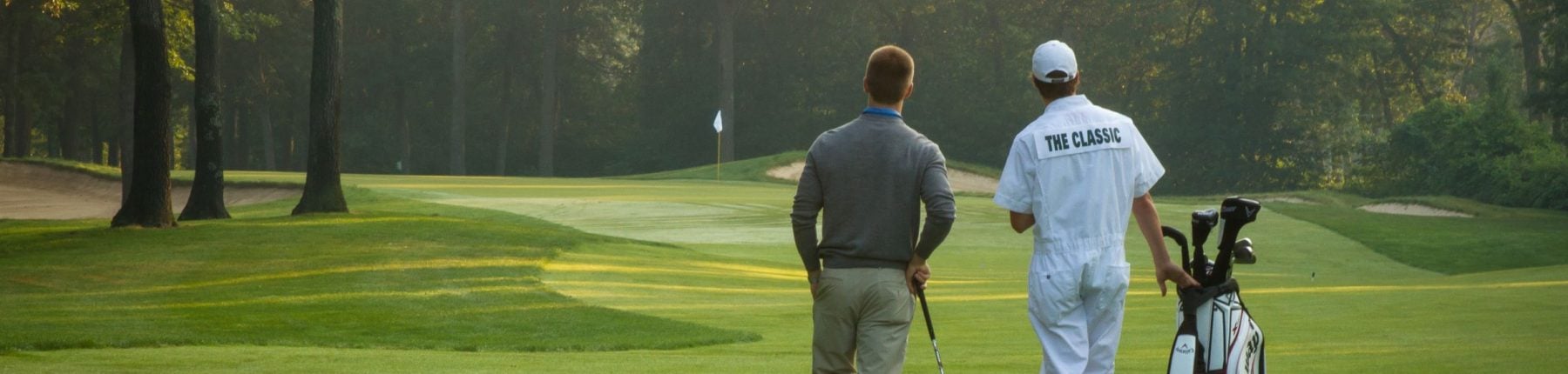 Rear view of a guest playing golf on the course