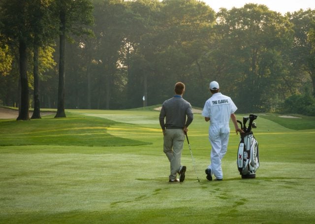 Rear view of a guest playing golf on the course