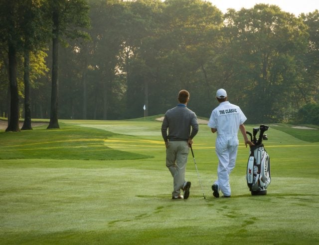 Rear view of a guest playing golf on the course