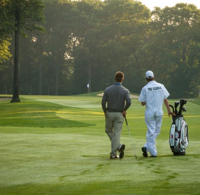 Rear view of a guest playing golf on the course