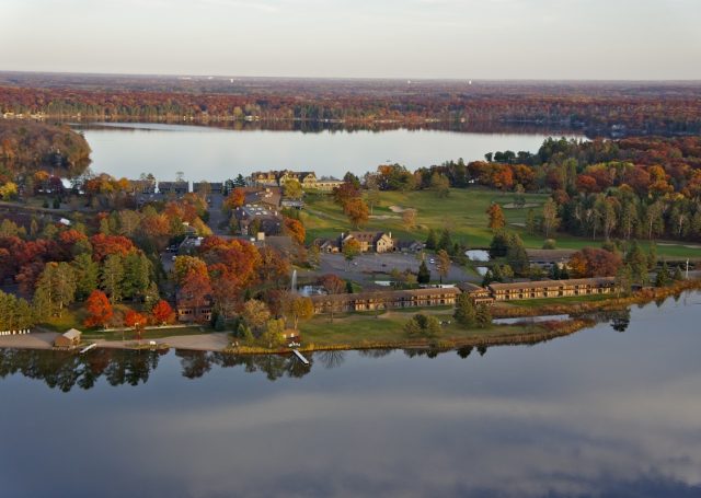 Stunning aerial view of Madden's on Gull lake in the fall with still waters and trees with changing leaves