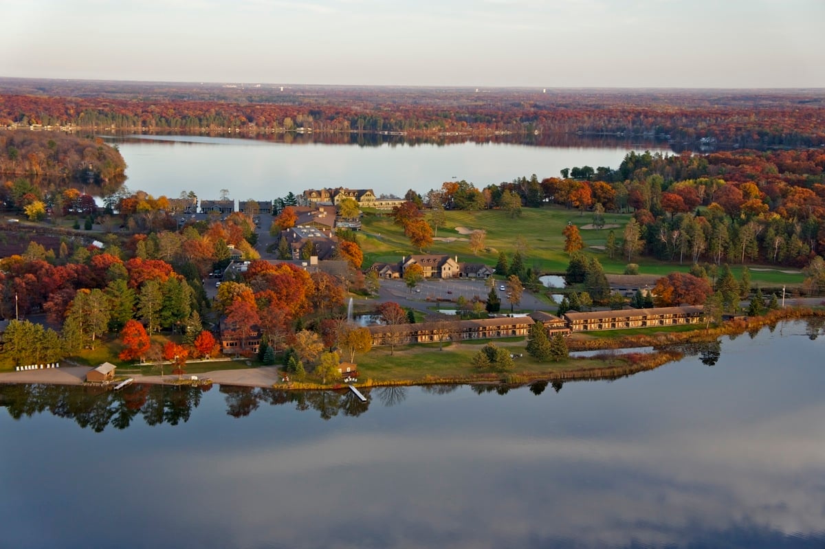 Stunning aerial view of Madden's on Gull lake in the fall with still waters and trees with changing leaves