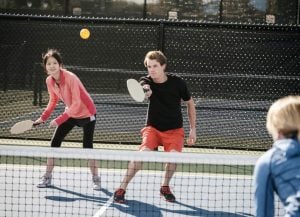 Girl and boy playing tennis at Maddens