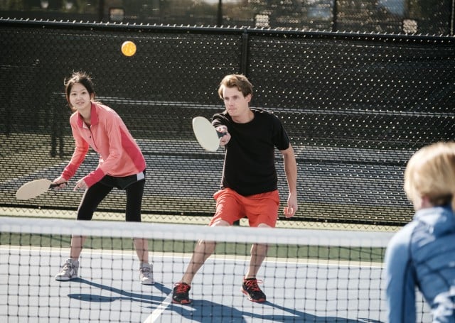 Couple playing pickleball outdoors on a court