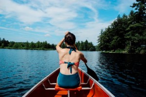 Woman in bathing suit canoeing on Gull Lake