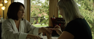 A beautician applying nail polish on a woman's nails