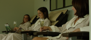 Close-up of Woman in robes drinking champagne and receiving pedicures