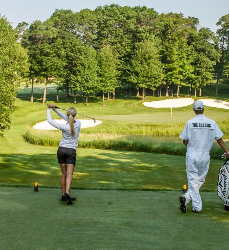 Woman taking golf swing at the Classic golf course at Madden's on Gull Lake