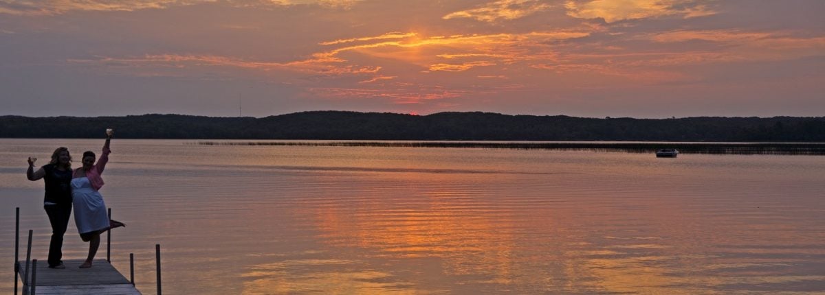 Breathtaking sunset of orange and pink skies over the lake at Wilson Bay