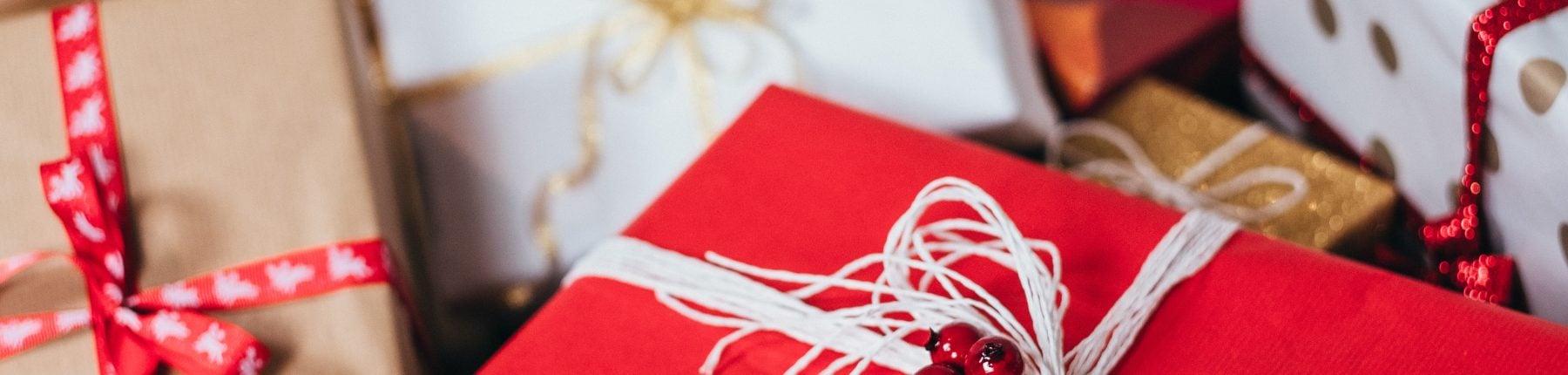 Beautifully wrapped white and red gift boxes with delicate string bows and adornments