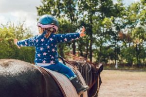 Rearview of a child riding a horse