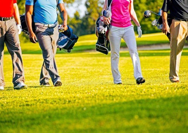 Half body shot of golfers walking on a golf course at Madden's on Gull Lake