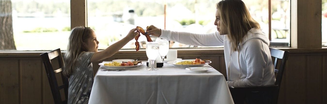 A mother and child splitting a bacon during breakfast at the Madden's Resort.