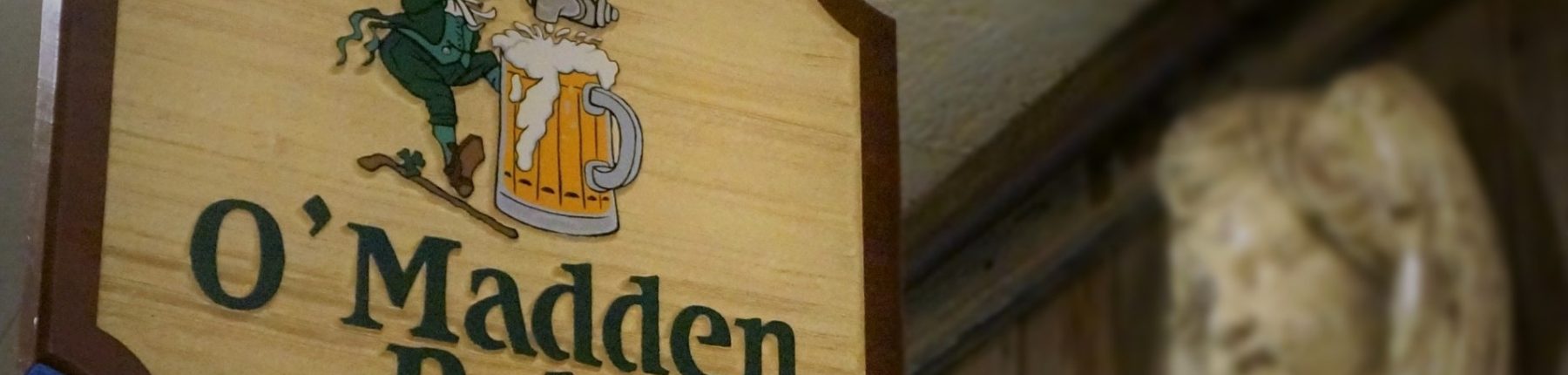 Closeup of the O'madden's pub wooden signage at the entrance of the pub