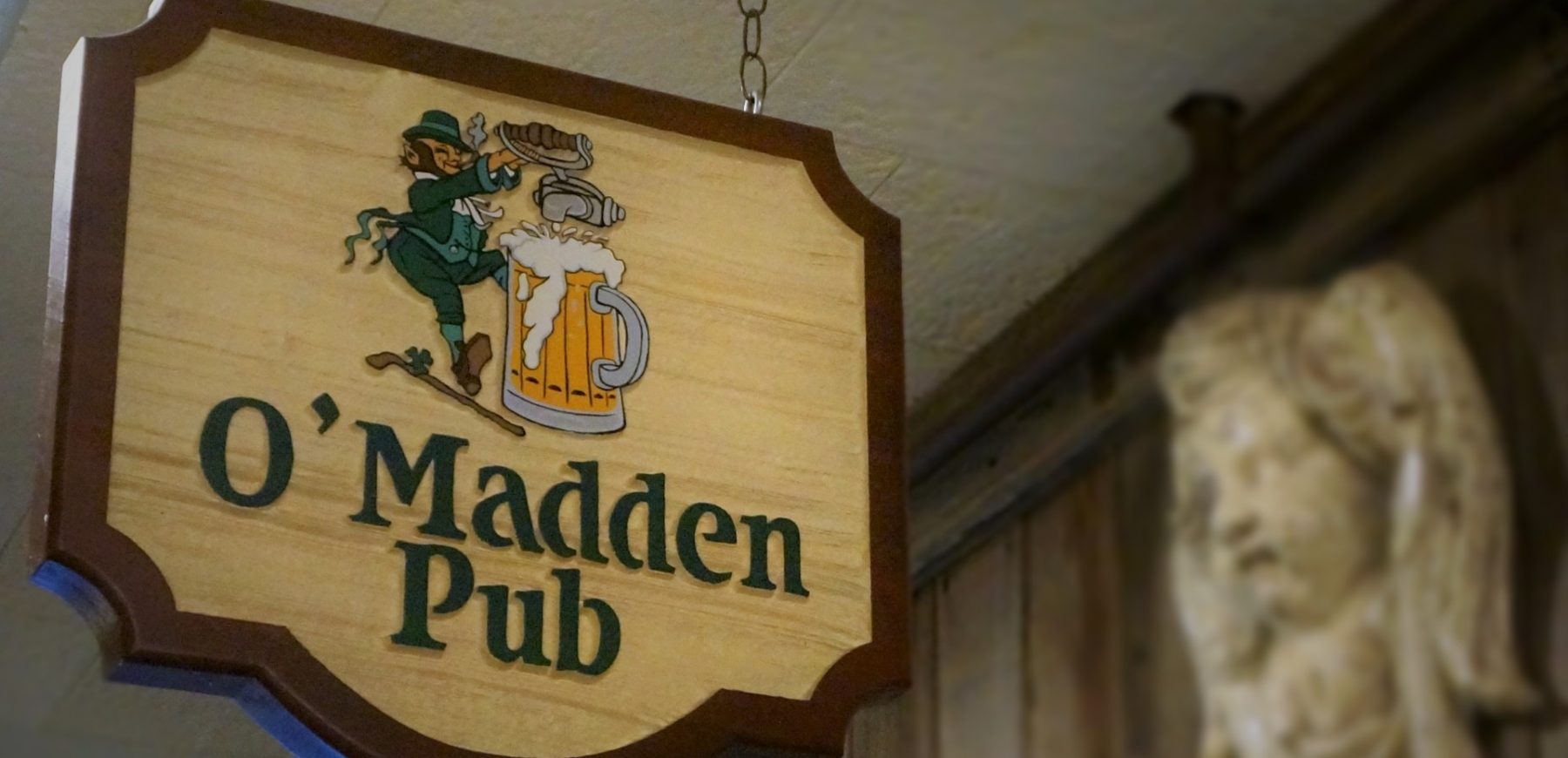 Closeup of the O'madden's pub wooden signage at the entrance of the pub