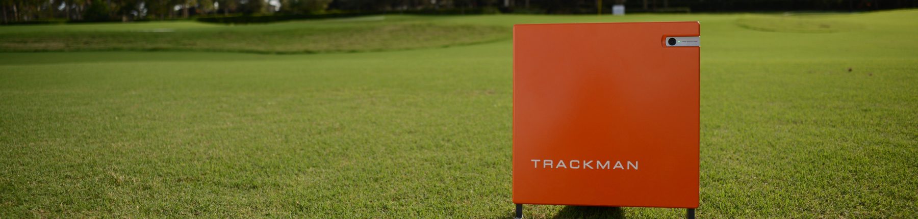 A Trackman golf tracker device placed on the grass.