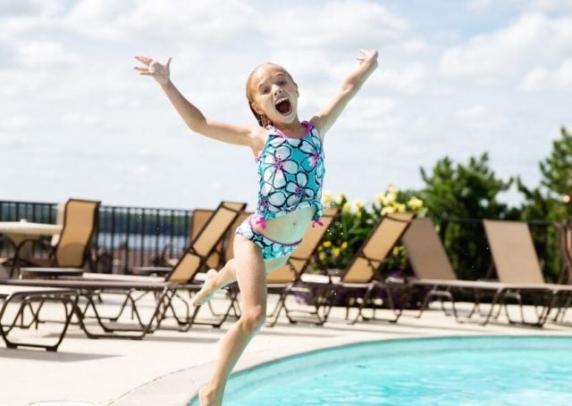 A girl jumping into the pool