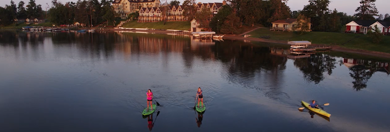 Two women paddle boarding at Madden's on Gull Lake Minnesota Resort