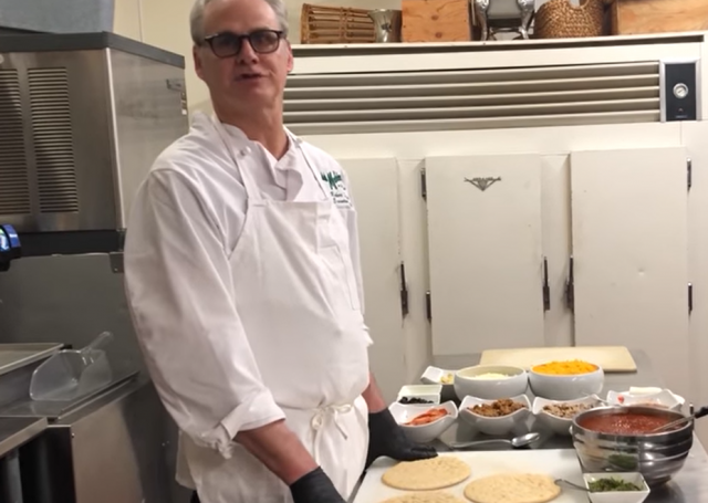 Madden's chef standing next to pizza ingredients