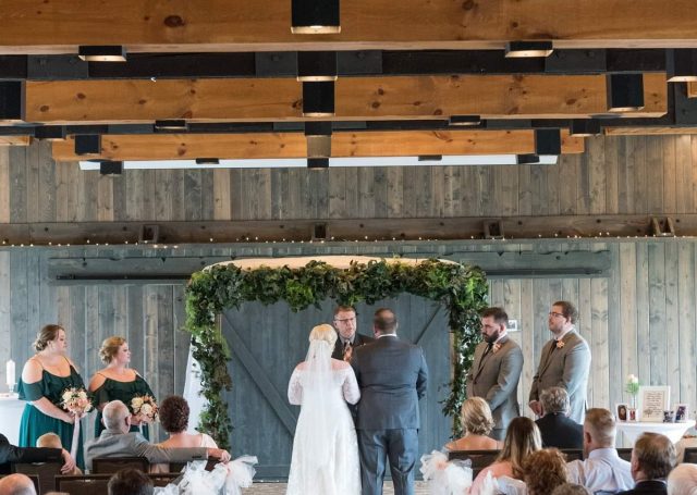 Rearview of a brides and groom at the aisle as seated guests look on