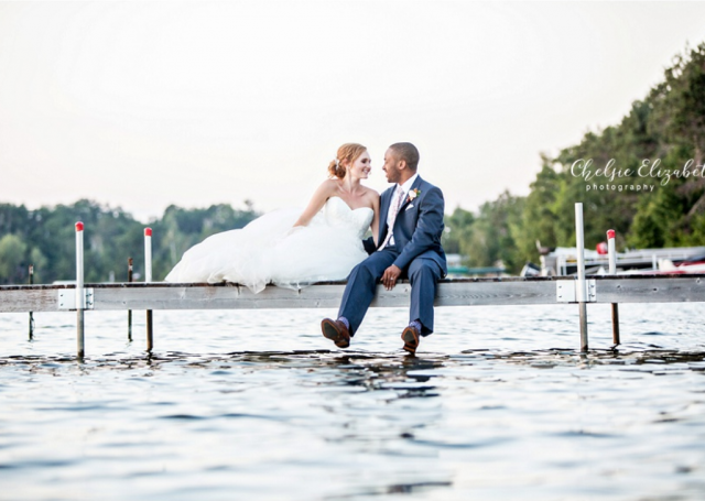 Bride and groom seating on the dock