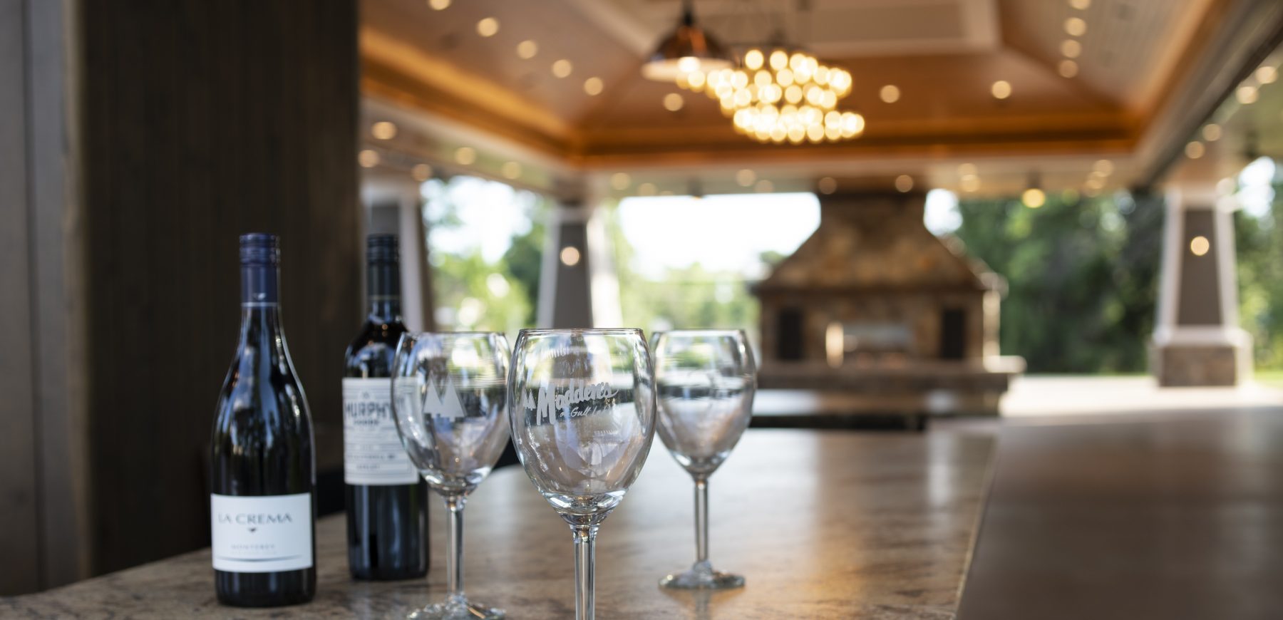 Two wine bottles next to wine glasses set on the counter