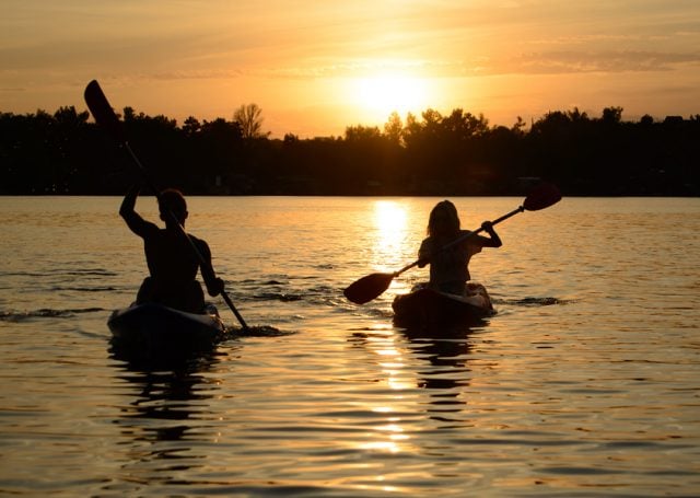 Young Couple Paddling Kayaks on the Gull Lake
