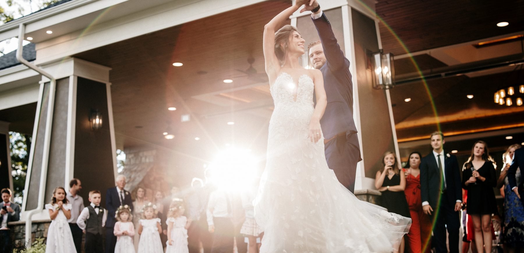 Bride and groom first dance as guests look on