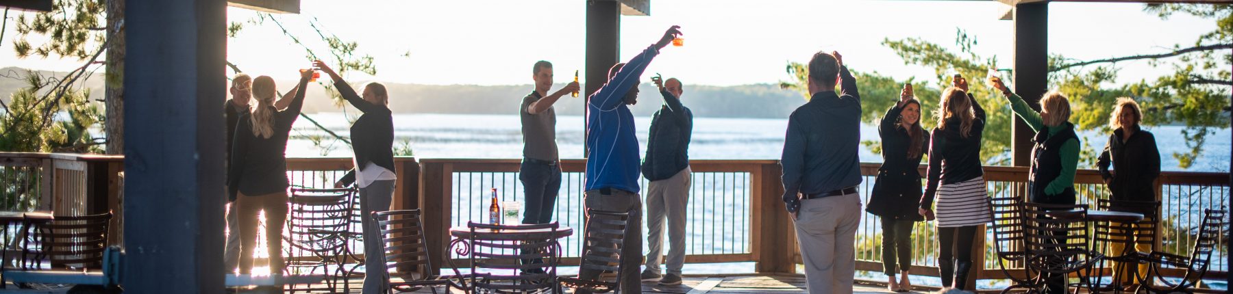 Group of people raising their glasses to toast in the Pavilion patio area