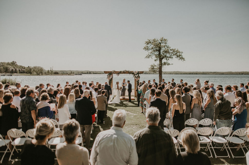 Wedding guests standing up to honor the bride and groom at the aisle