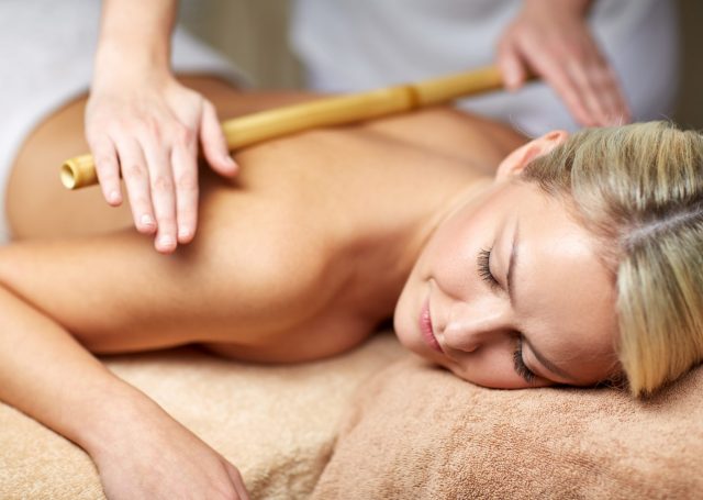 A woman receiving a bamboo massage from the therapist