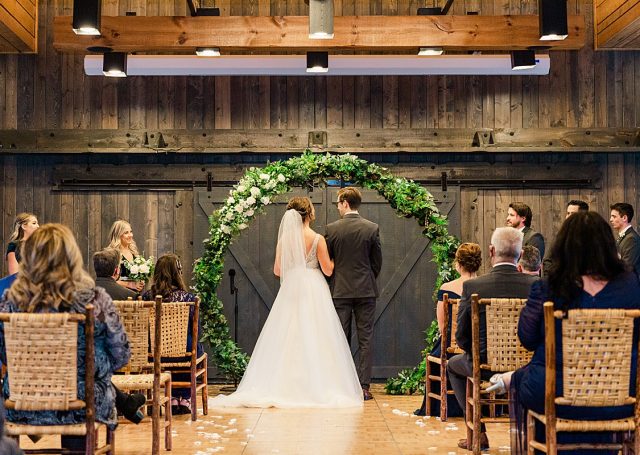 Rearview of a brides and groom at the aisle as seated guests look on