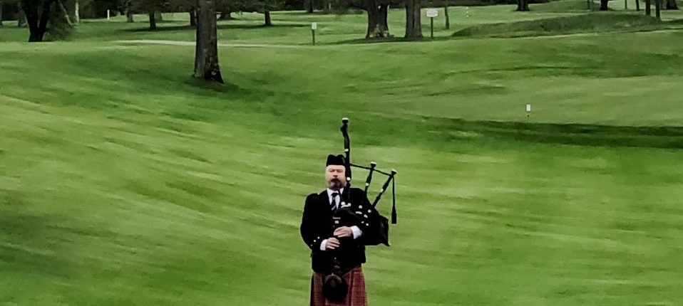 bagpiper plays from golf course