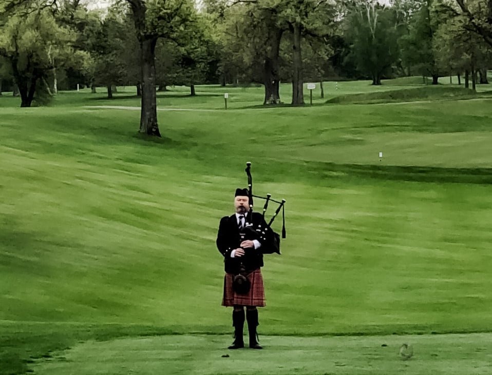 bagpiper plays from golf course
