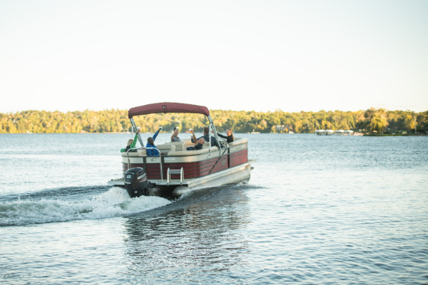 people wave from pontoon boat