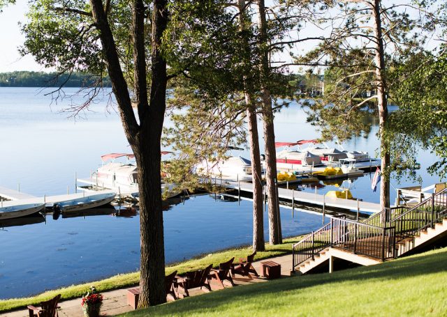 pontoon boats wait at dock on lake