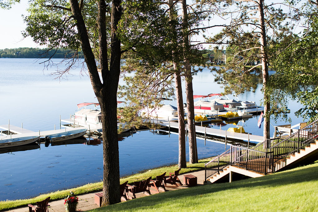 pontoon boats wait at dock on lake