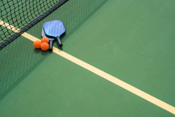 pickleball table with rackets and balls