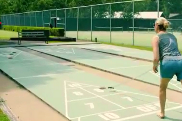 person plays shuffleboard