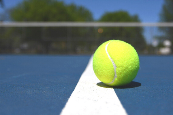 tennis ball on blue tennis court