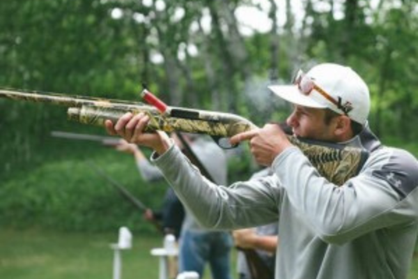 man holds rifle to fire