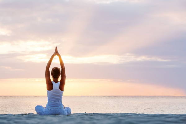 woman does a yoga pose on the beach