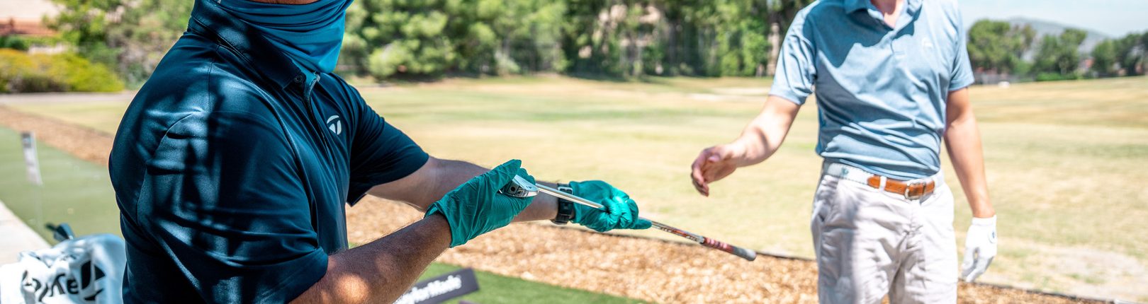 caddy hands a golfer a golf club