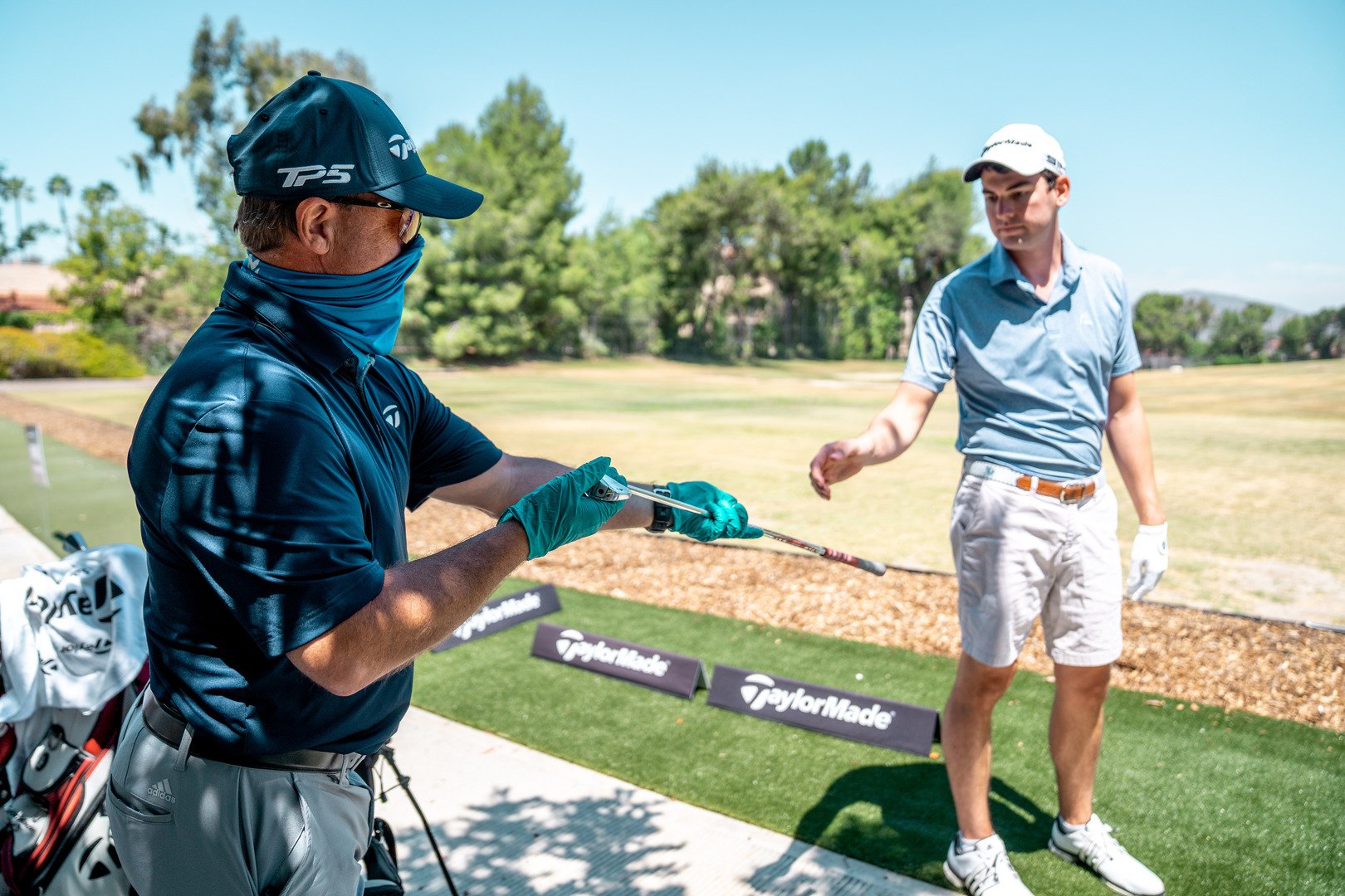 caddy hands a golfer a golf club