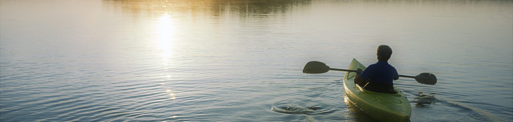 person kayaks on lake