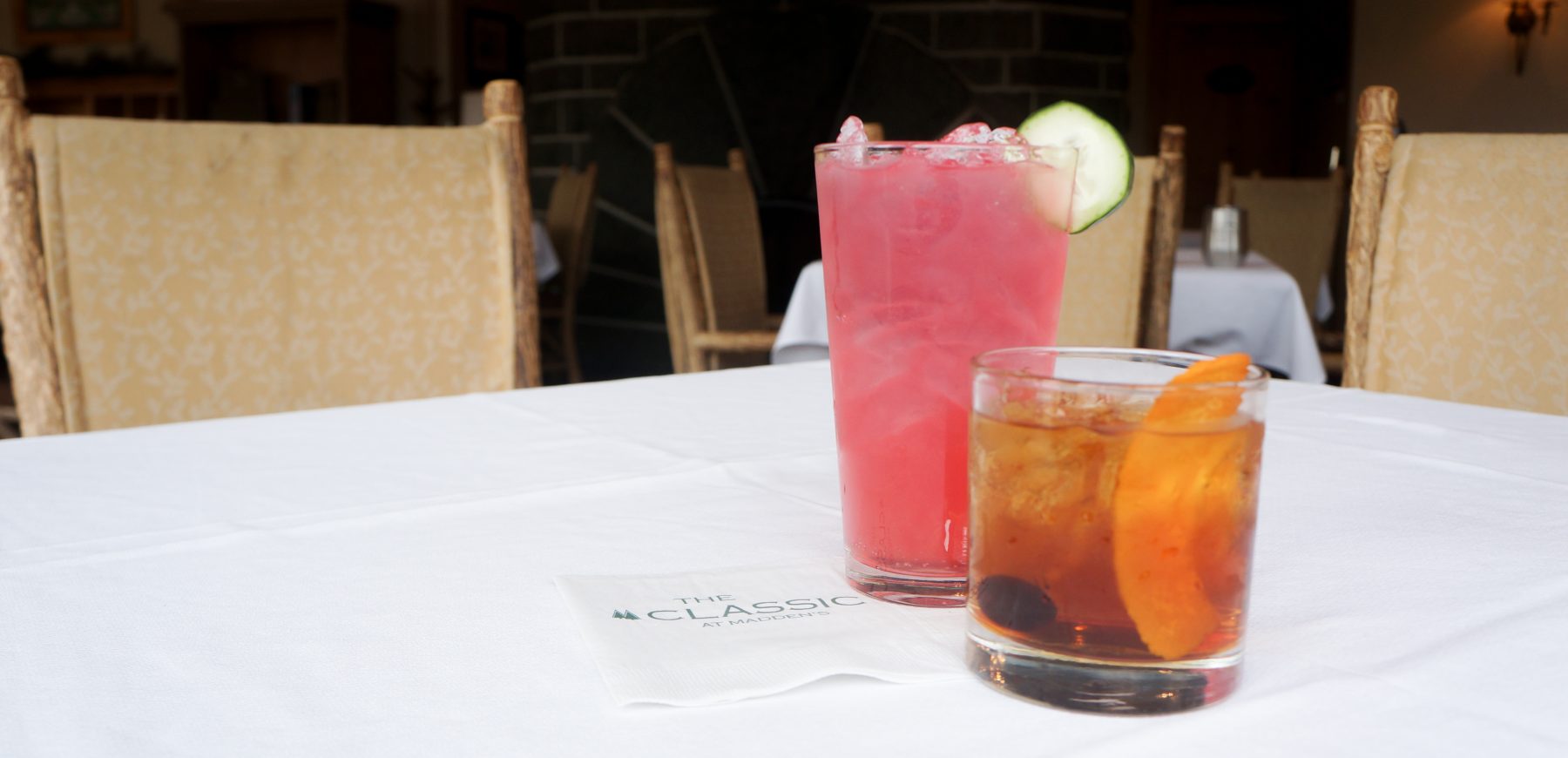 two cocktails on a while linen clothed table