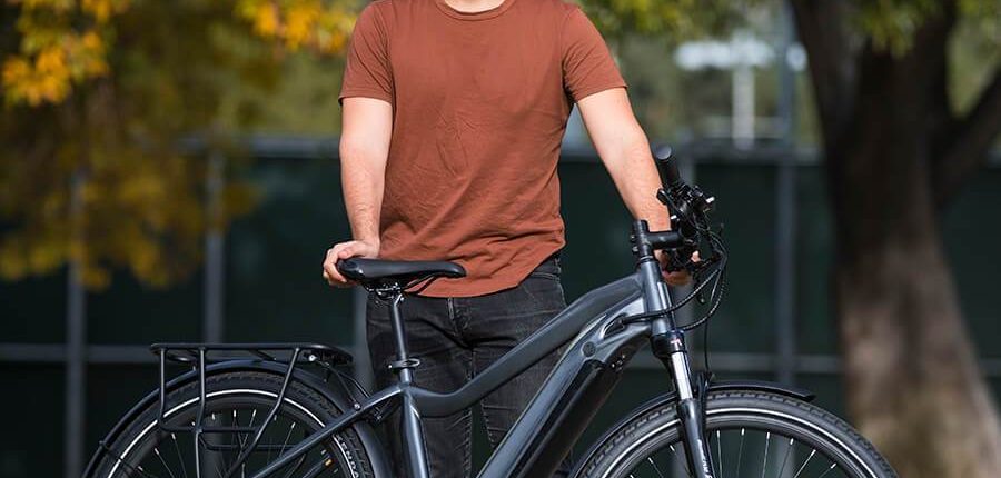 smiling man stands with bicycle